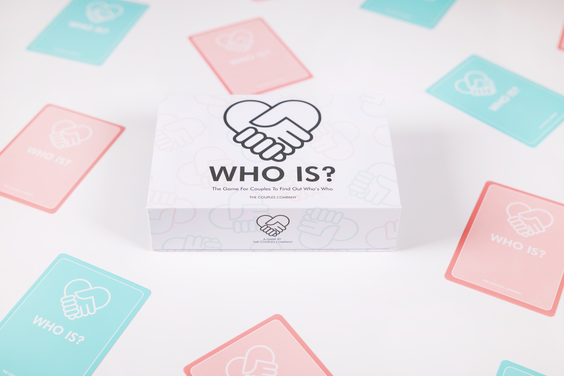 The WhoIs? card game box with pink and teal cards scattered around it